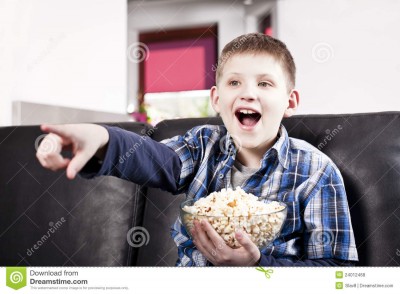 blond-happy-boy-watching-tv-eating-popcorn-24012468.jpg